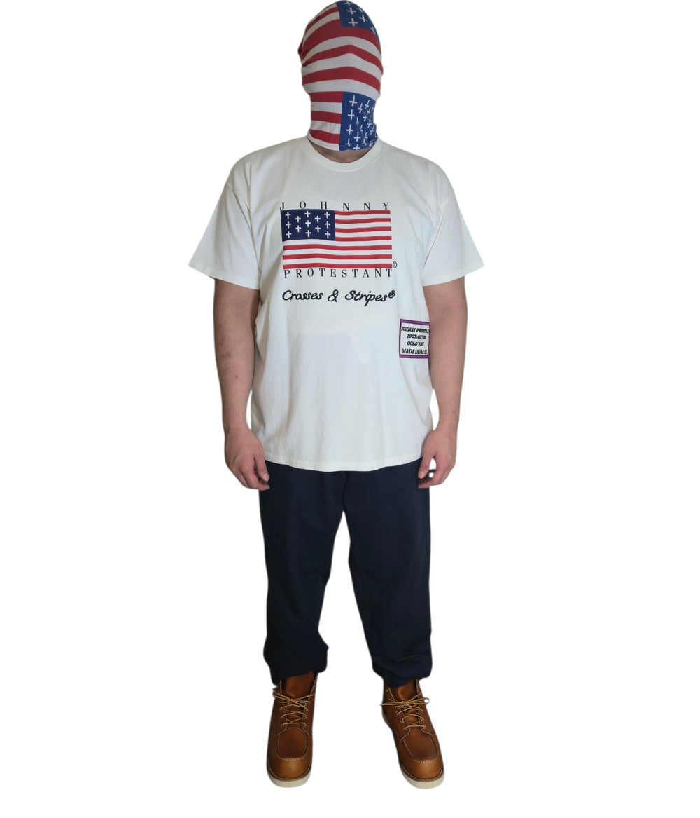 Model wearing Hopkinson Protestant Flag T-shirt, dark pants, and brown boots, front view
